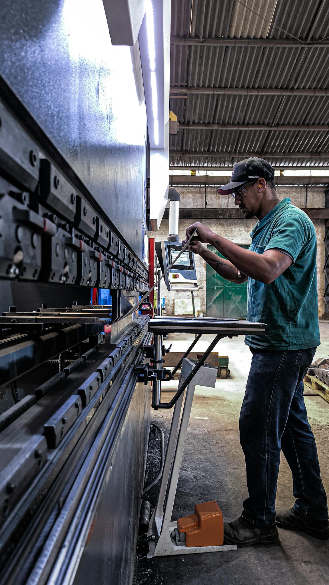 Engineer using machinery in a factory setting, focusing on precision and skill.